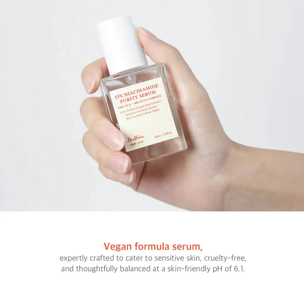 Niacinamide-serum in doorzichtige fles met witte pomp, vastgehouden in een hand.