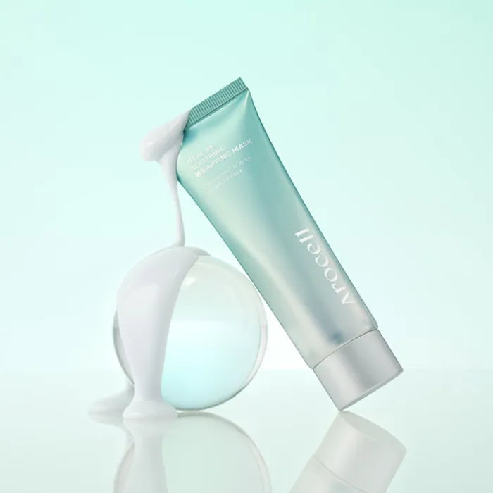 Arocell Hyal B5 Soothing Wrapping Mask tube leunend tegen glazen bol op mintgroene achtergrond