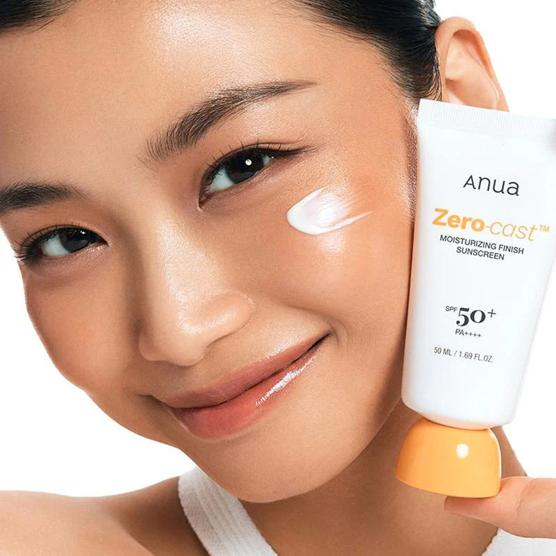 Model houdt Anua Zero-Cast Sunscreen SPF 50 tube tegen wang met zichtbare crème op witte achtergrond