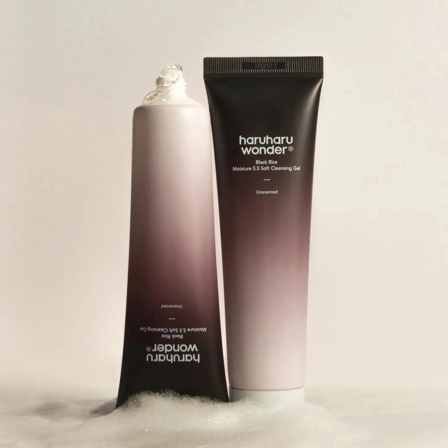 Haruharu WONDER Black Rice Moisture 5.5 Soft Cleansing Gel Haruharu Wonder reinigingsgel-tube naast flesje, met wit schuim op achtergrond