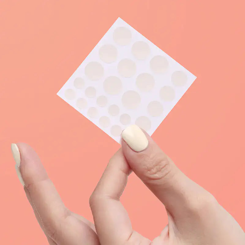 Hydrocolloïde acnepleister met meerdere ronde pleisters op drager, in hand