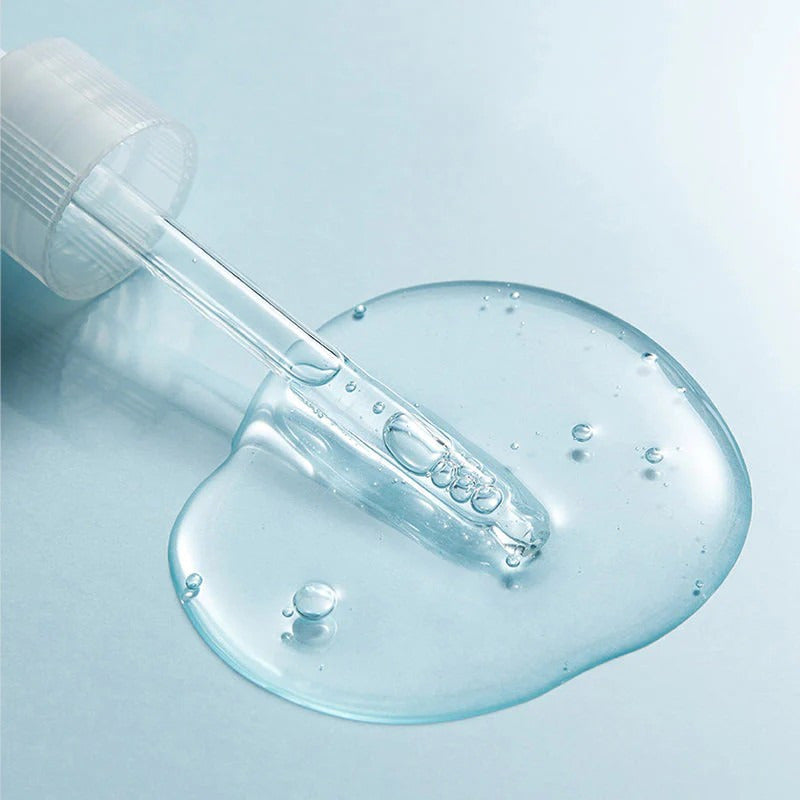 Serum pipet met druppel boven ronde transparante gel, met kleine belletjes.