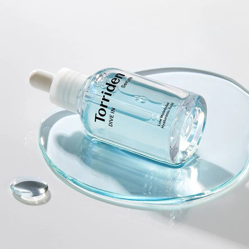 Torriden serumfles met witte druppelaar op schotel; transparant blauwe inhoud.
