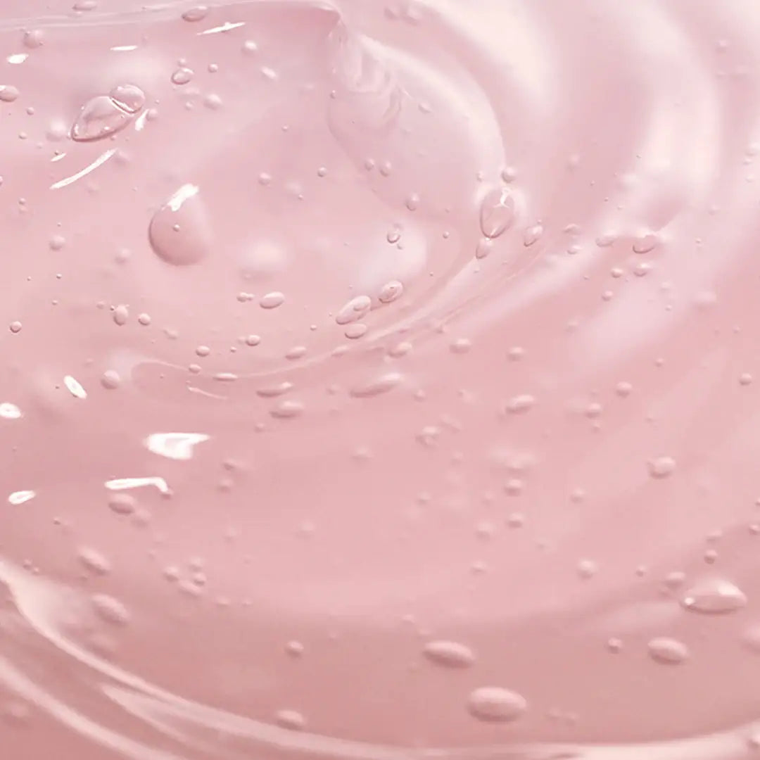 Glanzende zachtroze gel met zichtbare waterdruppels