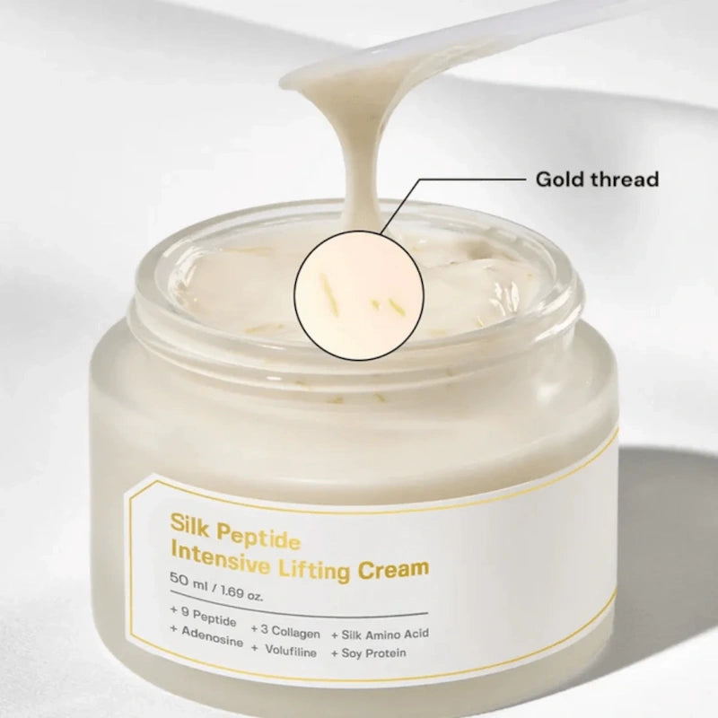 Close-up van SUNGBOON EDITOR Silk Peptide Intensive Lifting Cream met een spatel die de draderige crèmetextuur en goudkleurige draadjes laat zien.