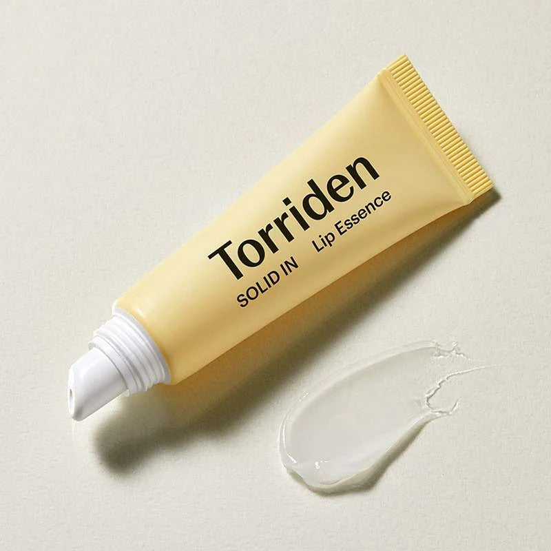 Torriden lipessence tube met aangebrachte crème op vlak oppervlak
