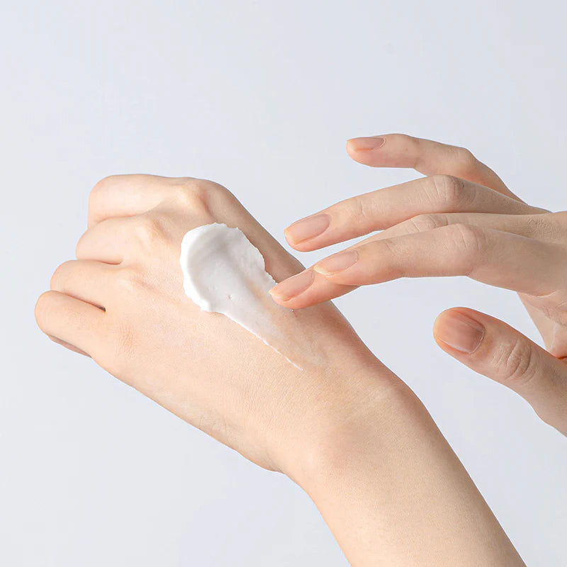 TOCOBO multi-ceramidecrème smeert op hand met witte crème