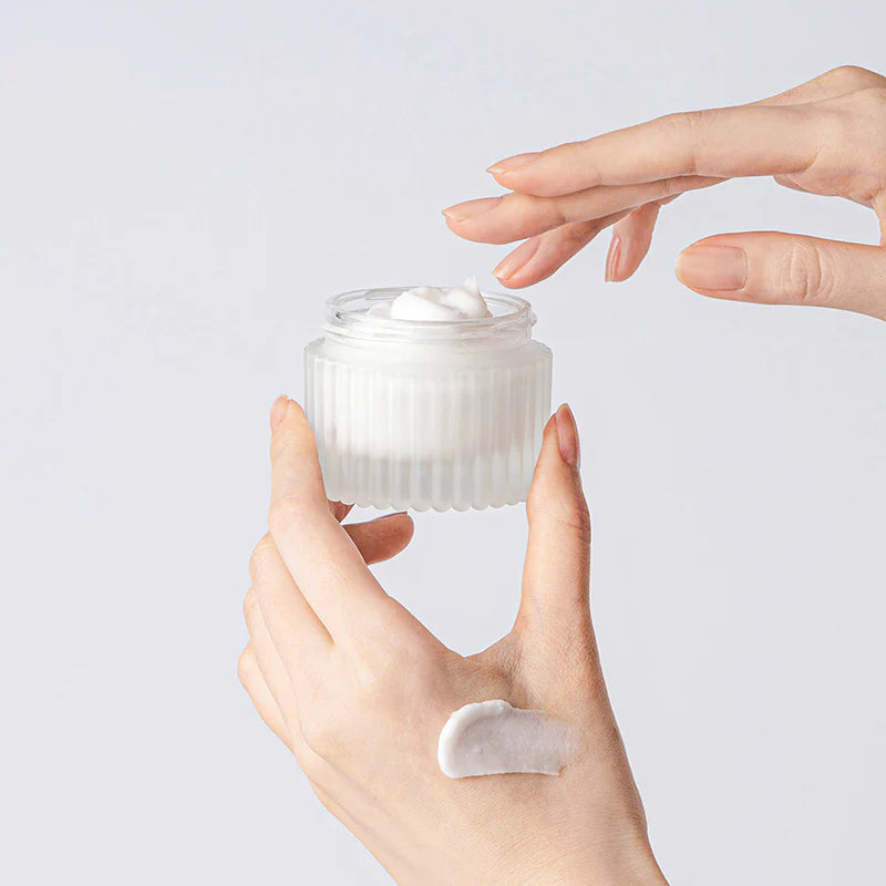 TOCOBO multi-ceramidecrème pot met witte crème op de vinger