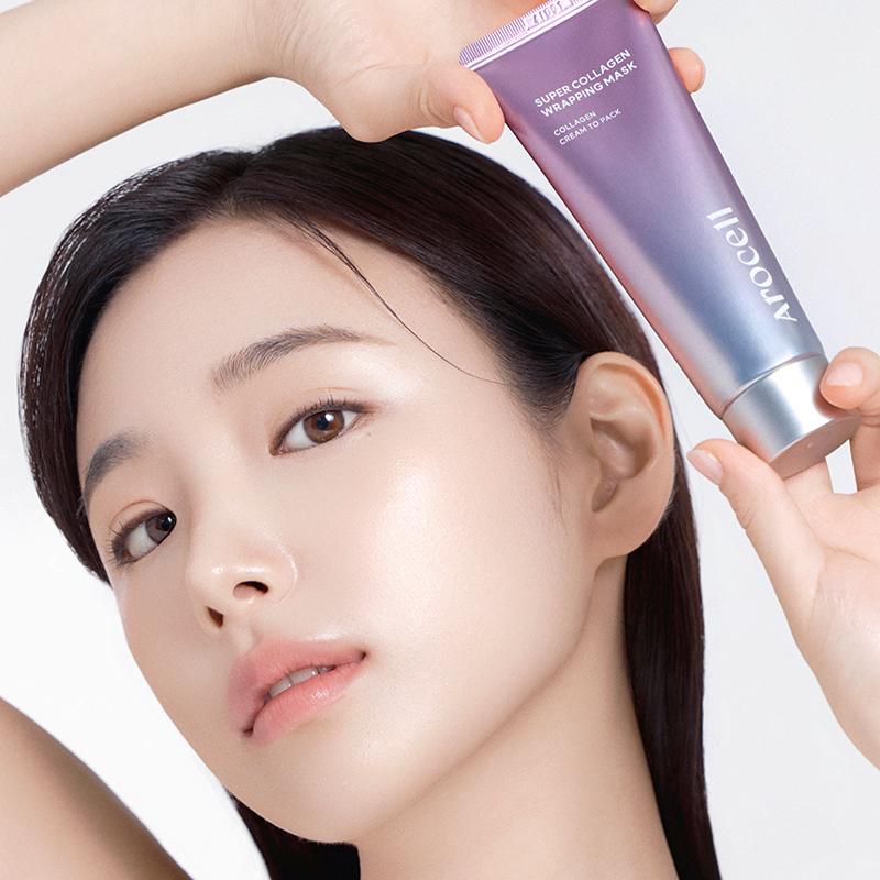 Model houdt Arocell Super Collageen Wrapping Masker tube vast naast gezicht op witte achtergrond