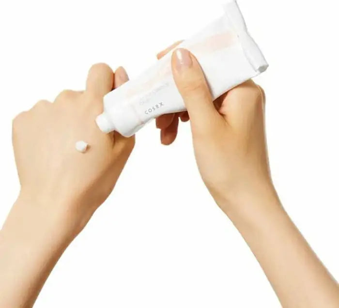 Balancium ceramide handcrème tube met witte crème op hand, tube in gebruik
