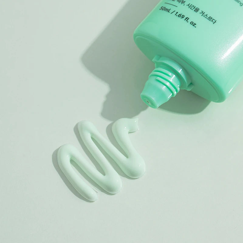 Witte crèmetextuur van de Benton Air Fit UV Defense Sun Cream SPF50+ PA++++ uit de mintgroene tube op lichtgrijze achtergrond