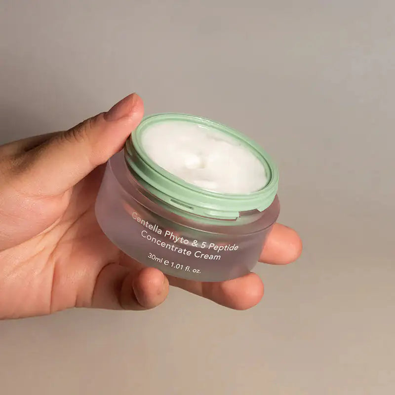 Haruharu WONDER Centella Phyto & 5 Peptide Concentrate Cream Gezichtscrème in pot, doorzichtige groen deksel in hand