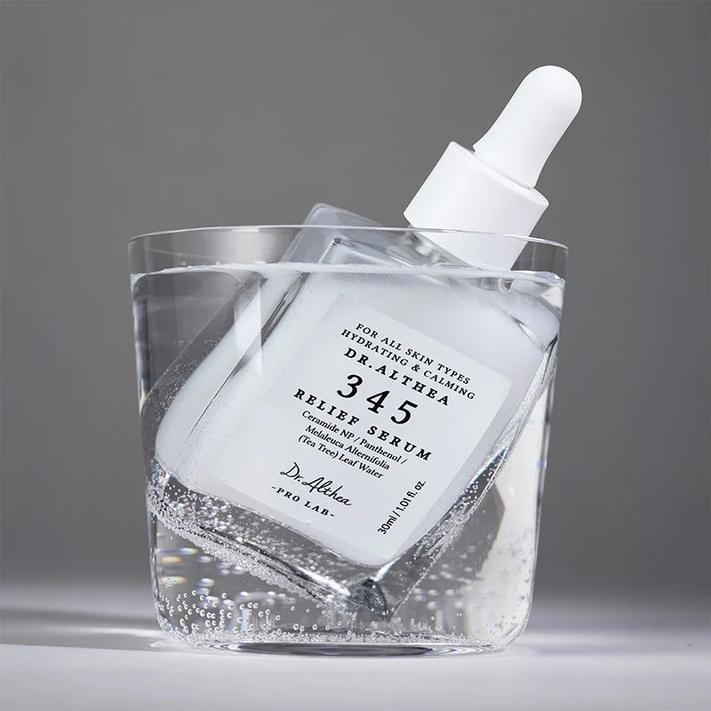 In glas water Dr.Althea 345 Relief Serum in een glas water met luchtbelletjes rondom de fles.