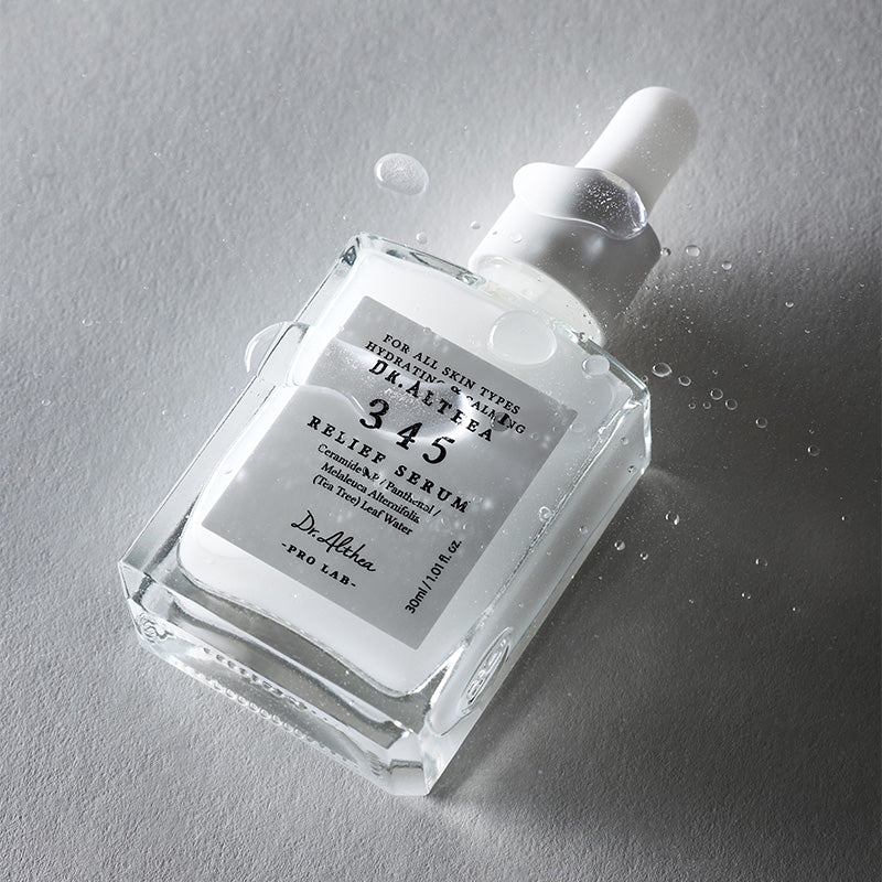Lifestyle Dr.Althea 345 Relief Serum op een grijze ondergrond met waterdruppels rondom de fles.