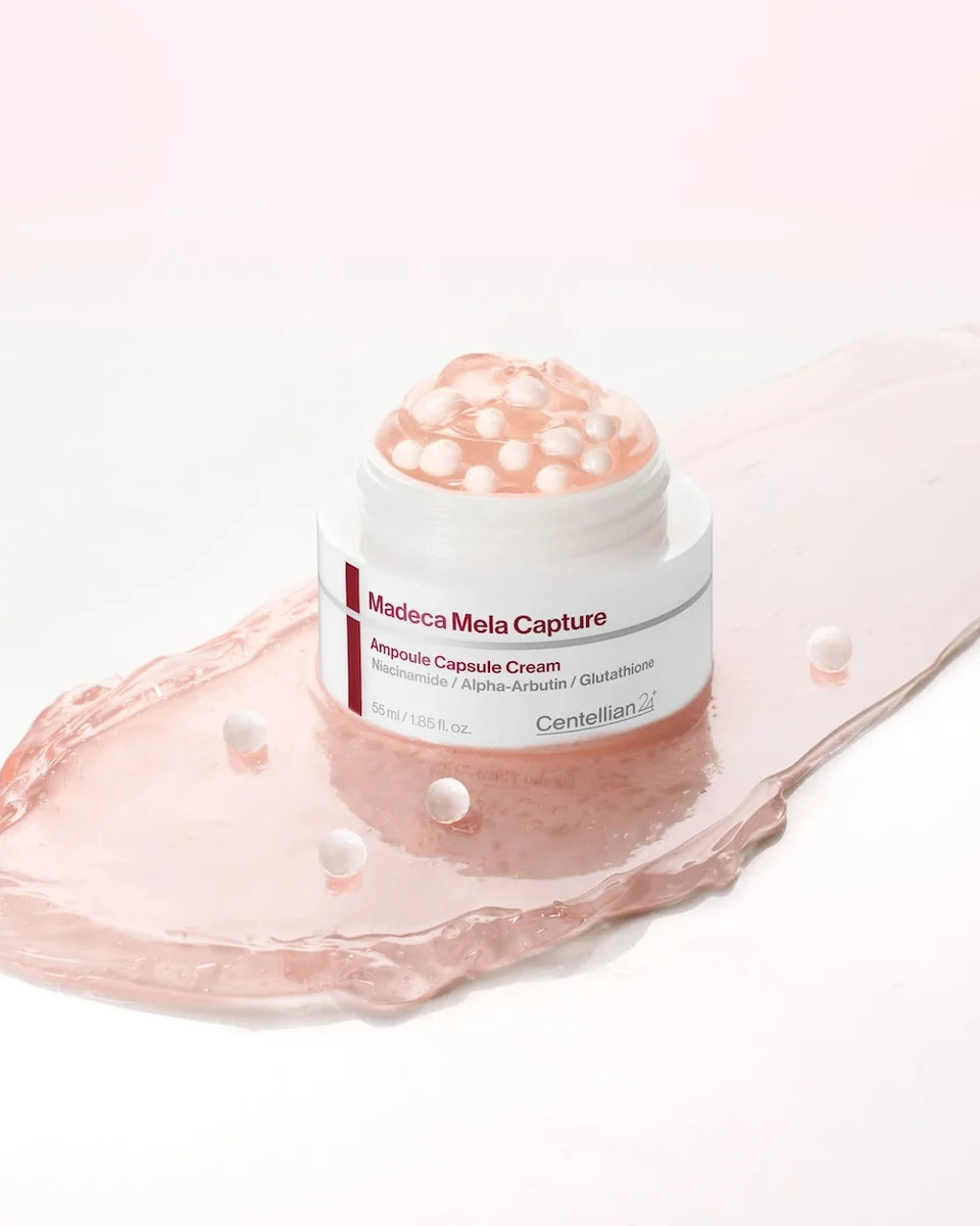 Close-up van de open Centellian24 Madeca Mela Capture Ampoule Capsule Cream met witte ampulcapsules in roze crème.