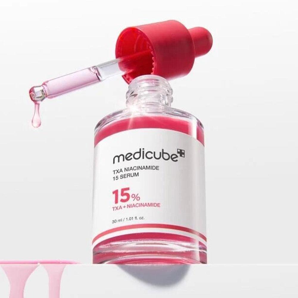 Close-up van Medicube TXA Niacinamide 15 Serum met pipet en glanzende serumdruppel

