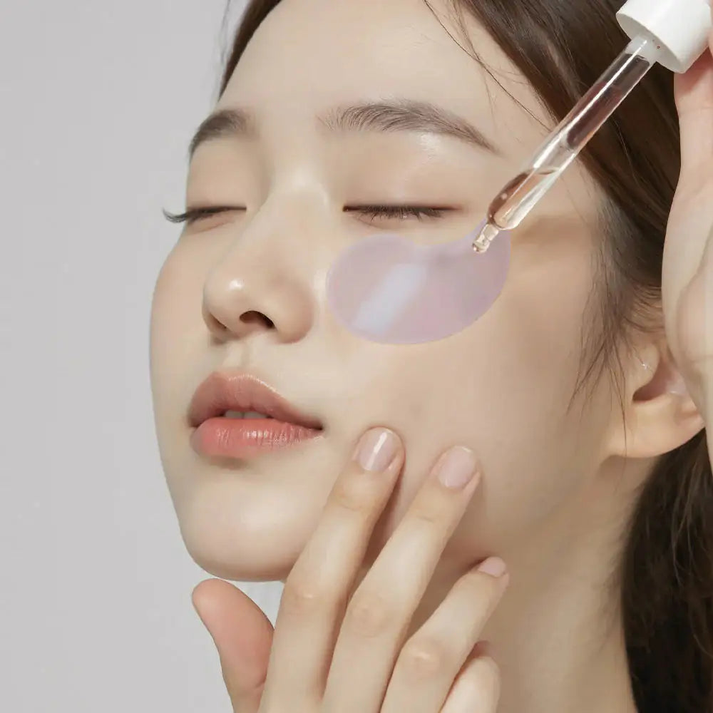 Hydrogel oogpatch op de huid onder het oog, met applicator bij het gezicht