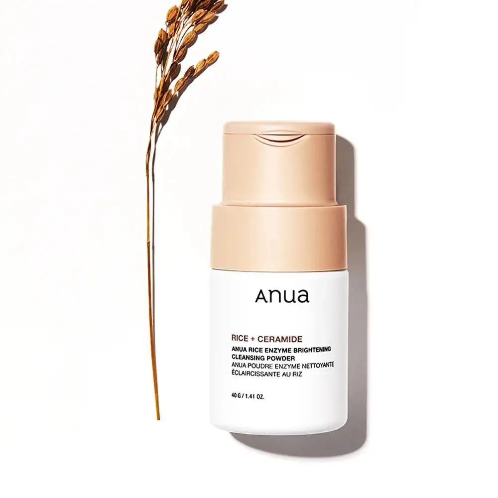 Anua Rice Enzyme Brightening Cleansing Powder Anua reinigingspoederfles met beige dop naast rijsthalmen