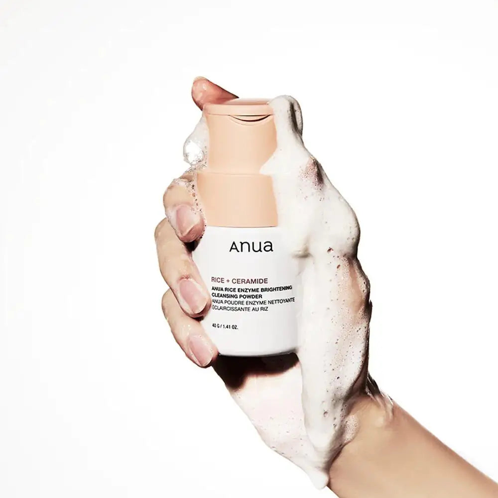 Anua Rice Enzyme Brightening Cleansing Powder Anua reinigingspoederfles in hand met schuim op de huid