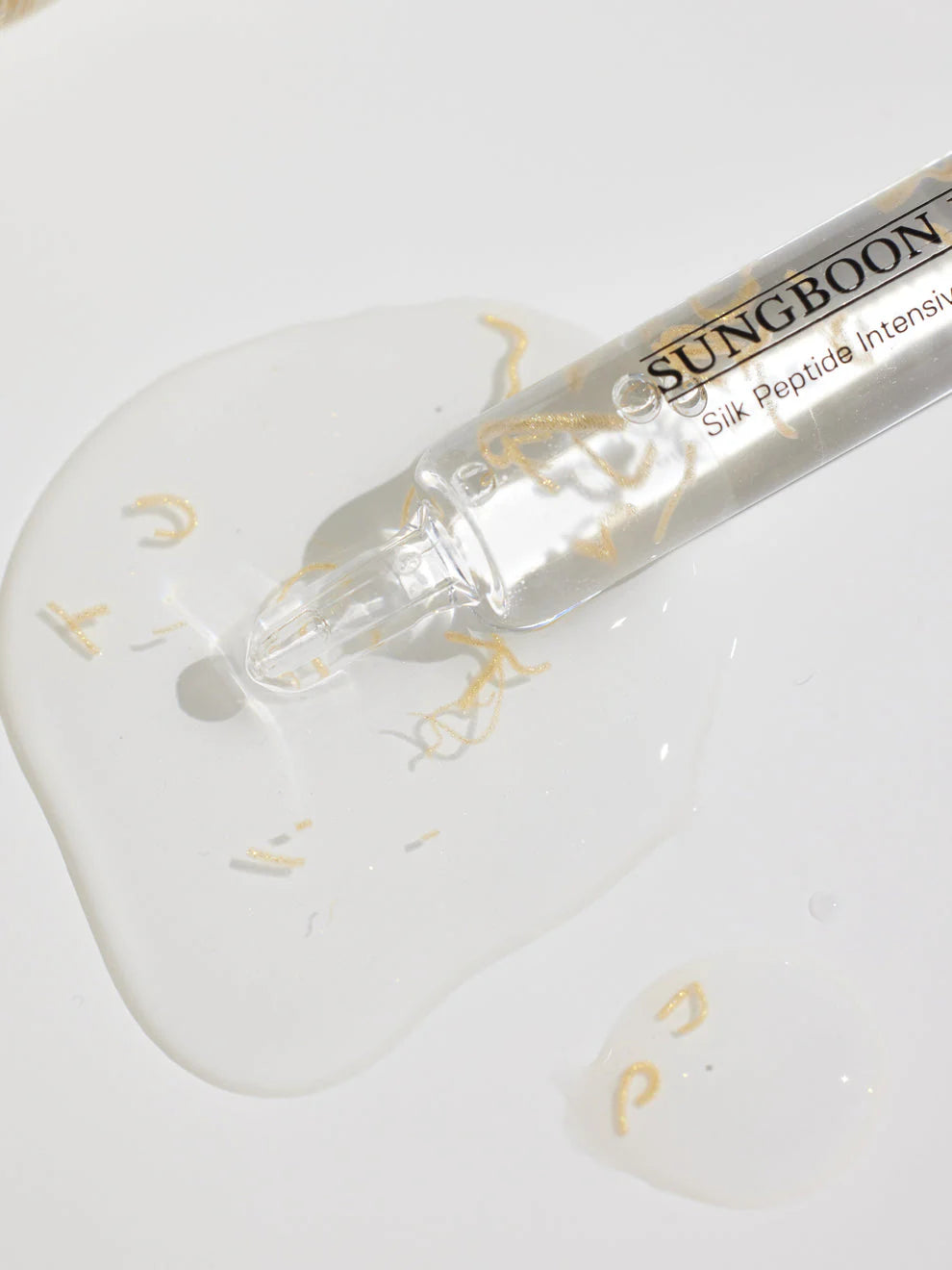 Zijdepeptide-ampul met transparante vloeistof op lepel, met applicator