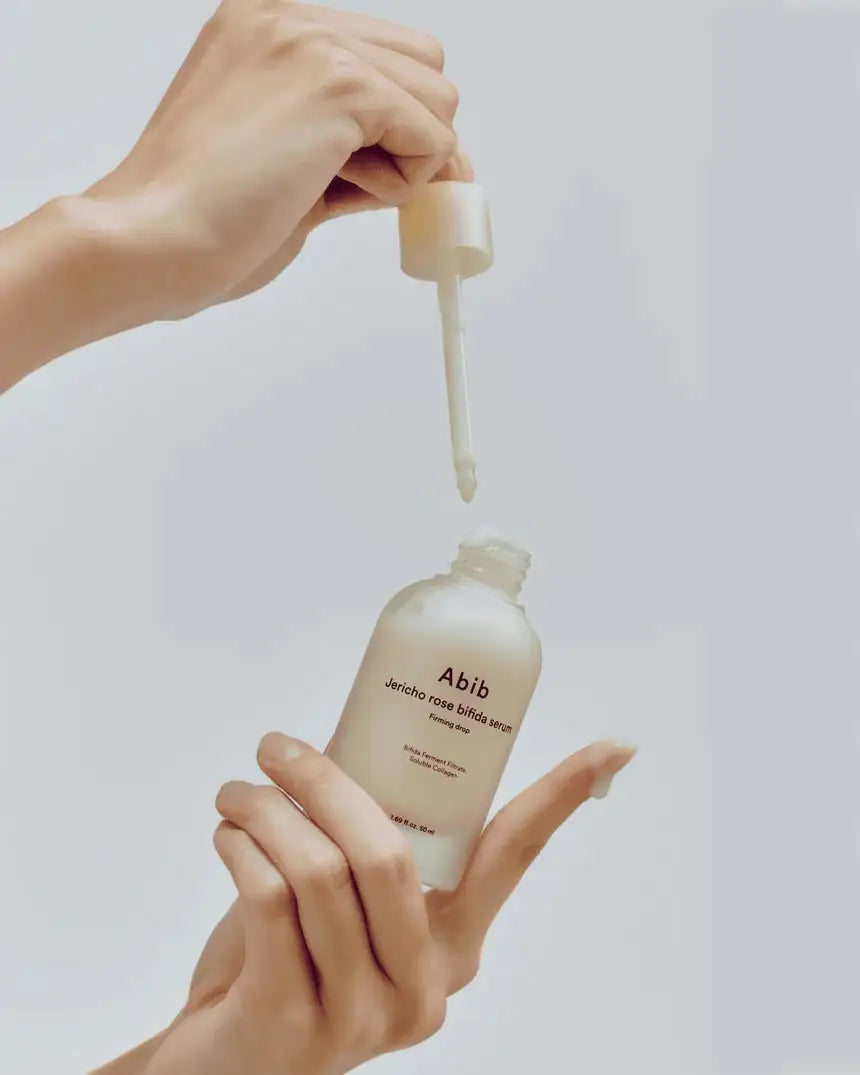 Abib Jericho Rose Bifida Serum Firming Drop Abib serumflacon met druppelaar; handen gieten een romige vloeistof