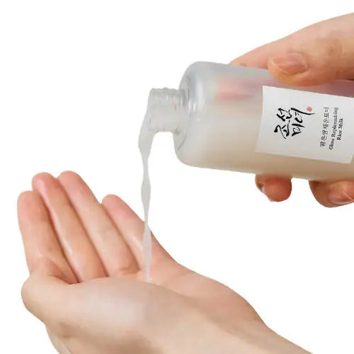 Dispenserfles met rijstmelk, handen gieten vloeistof op de hand