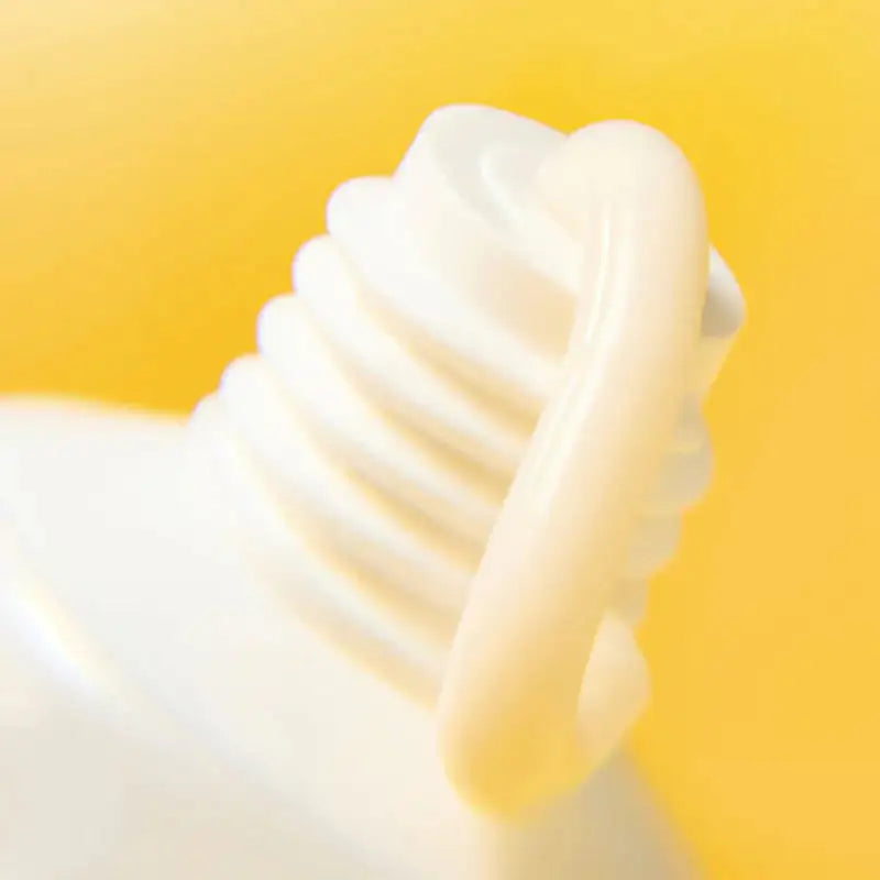 Romige witte crèmeklodder met gladde swirls op hand