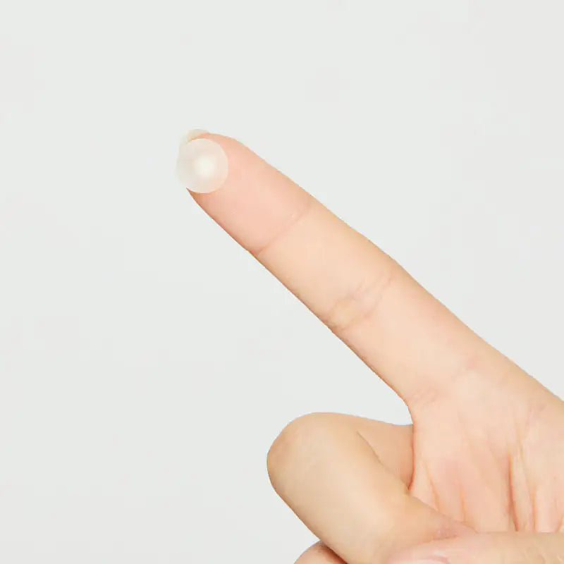 Ronde hydrocolloïde acnepleister op top van vinger