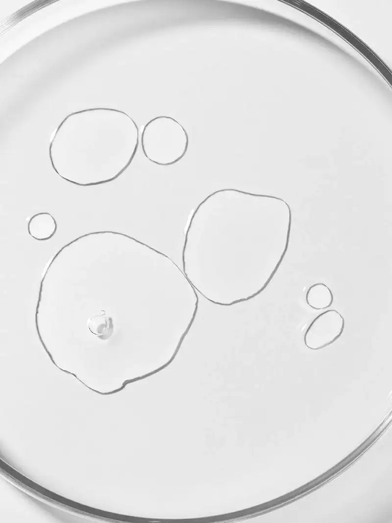 Cica-toner vloeistof in close-up, druppelachtige vormen in een ronde schaal