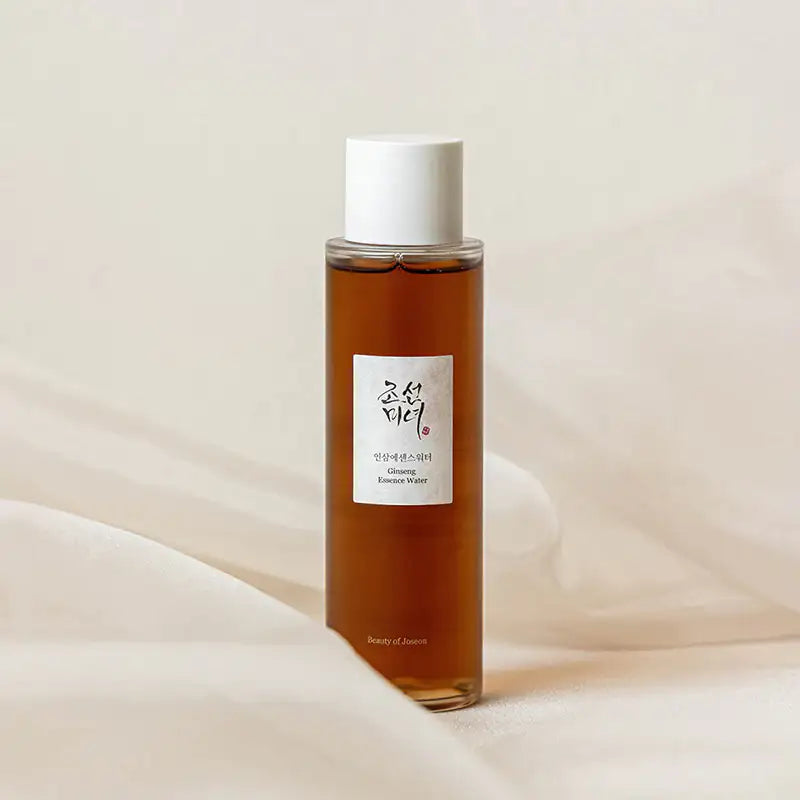 Beauty of Joseon Ginseng Essence Water Ginseng-essencewaterflesje met witte dop op zachte witte stof
