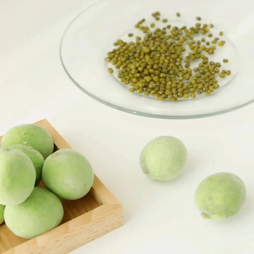 Groene pruimvruchten en zaadjes op een glazen schaaltje
