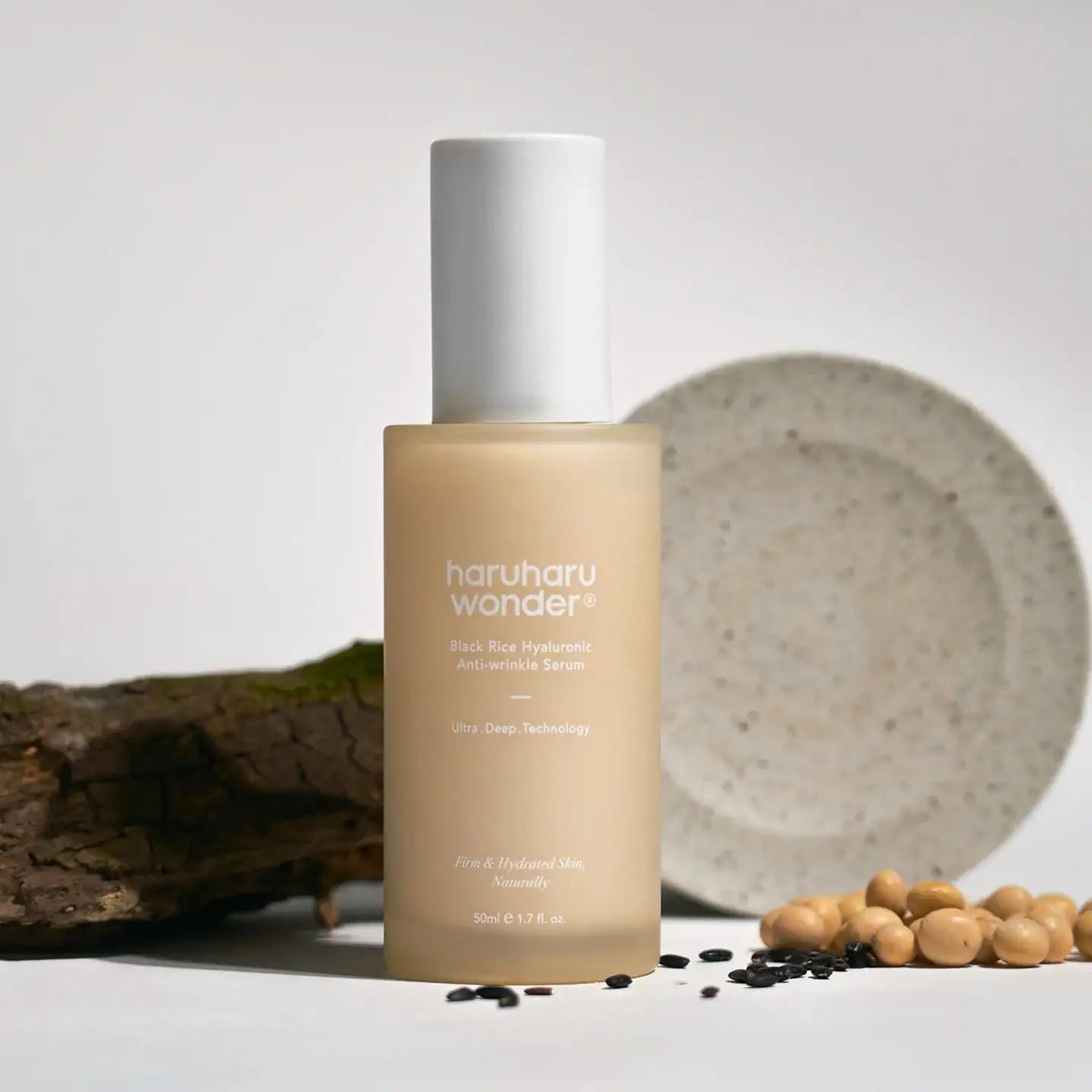 Haruharu WONDER Black Rice Hyaluronic Anti-Wrinkle Serum Serumfles haruharu wonder met witte dop, beige fles naast rijstkorrels