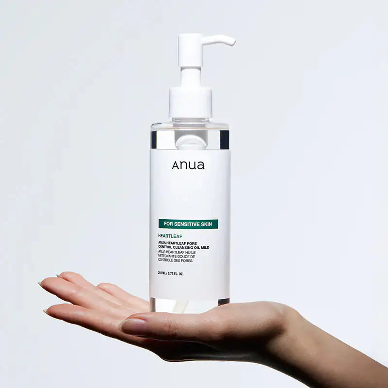 Anua Heartleaf Pore Control Cleansing Oil Mild Reinigingsolie fles Anua met witte pomp, handen voor de fles