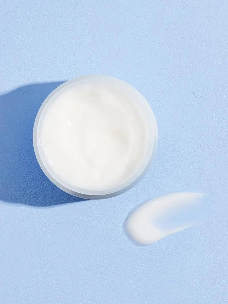 Hyaluroncrème met witte, romige textuur op deksel van pot
